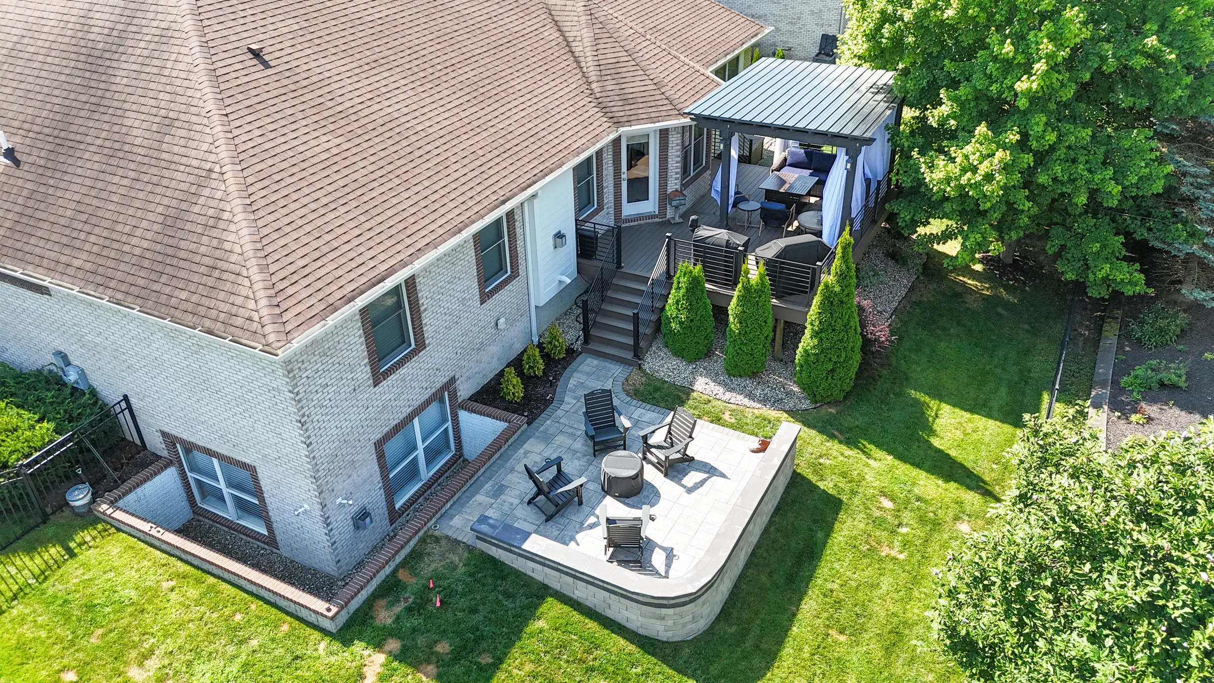 Aerial view of paver patio, fire pit, and deck in Carmel.