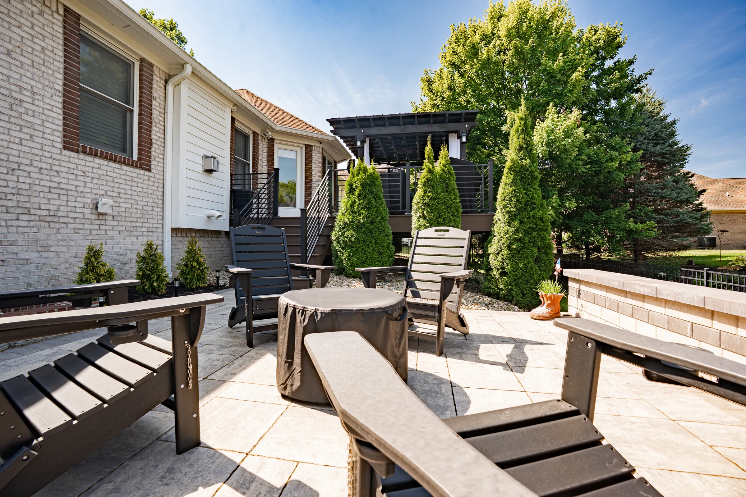 Paver patio with fire pit alongside a deck in Carmel.