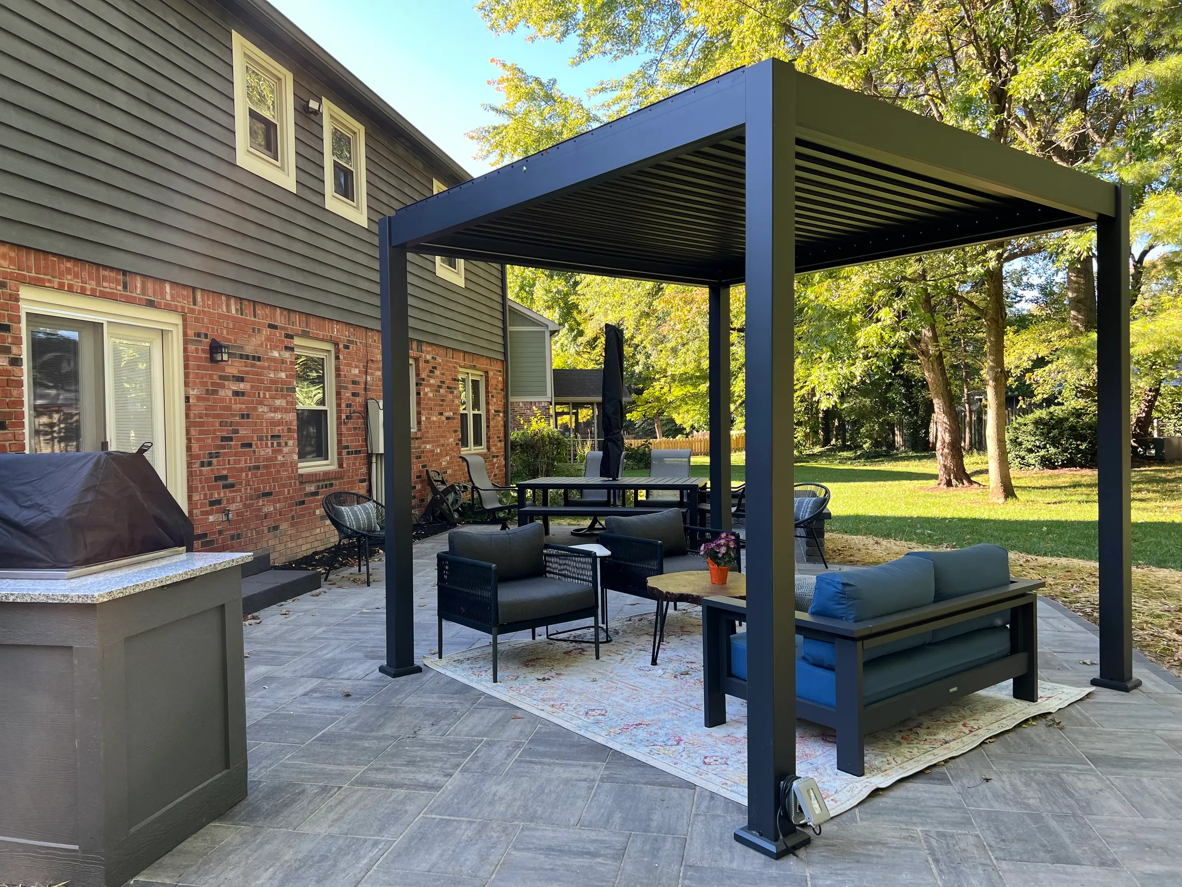 Black louvered pergola paver patio in Carmel.