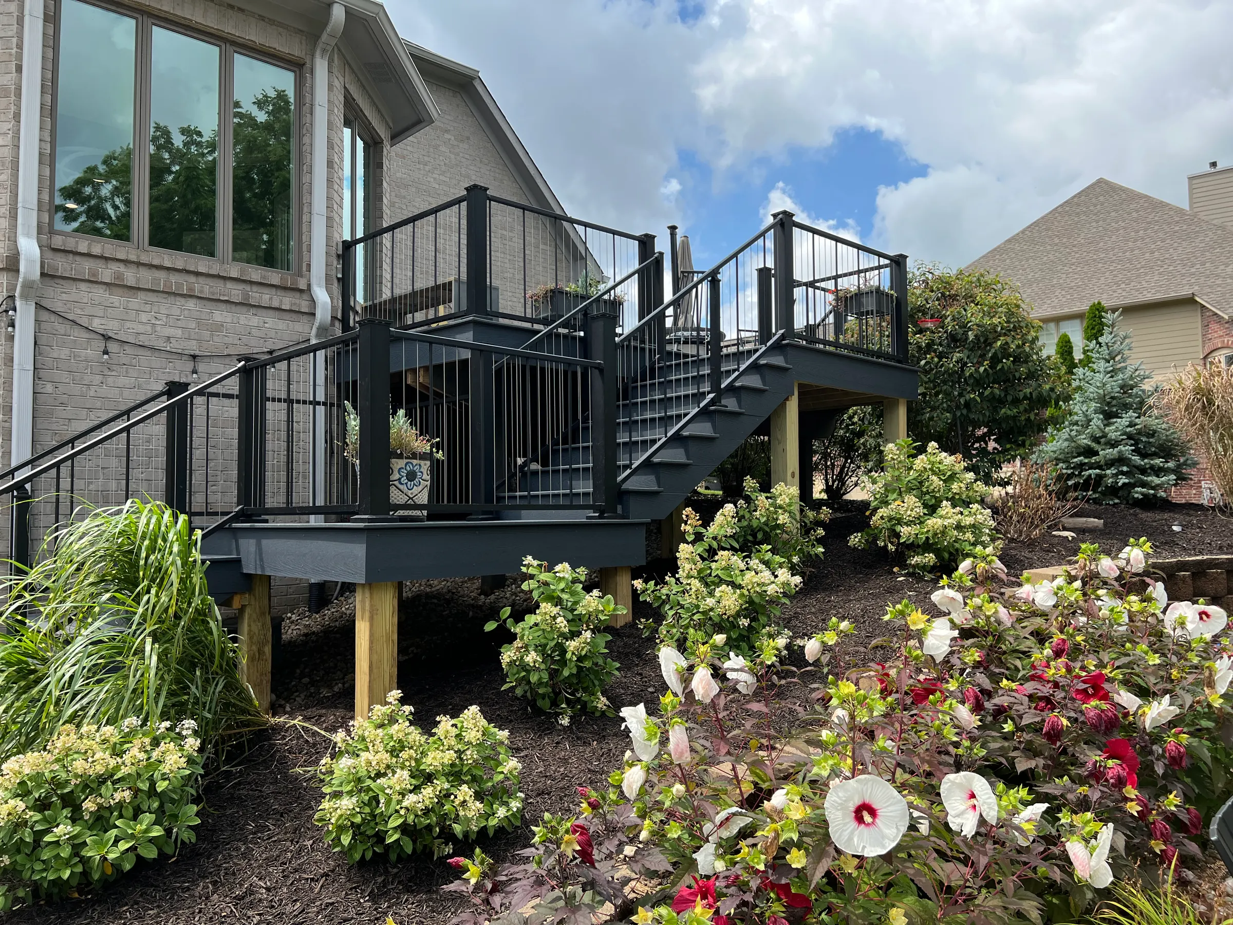 Multi level deck stairs black railing landscaping in Noblesville.