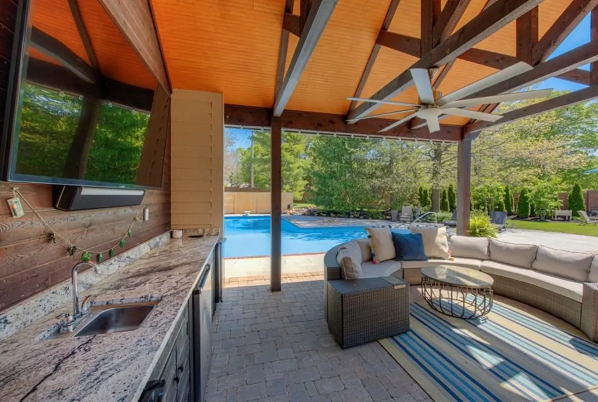Outdoor living with pool, pavilion, entertainment center, and bar.