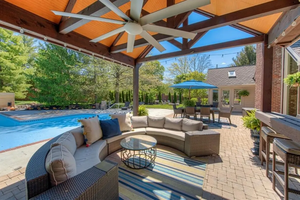Outdoor living area with pool, pavilion, and lounge.